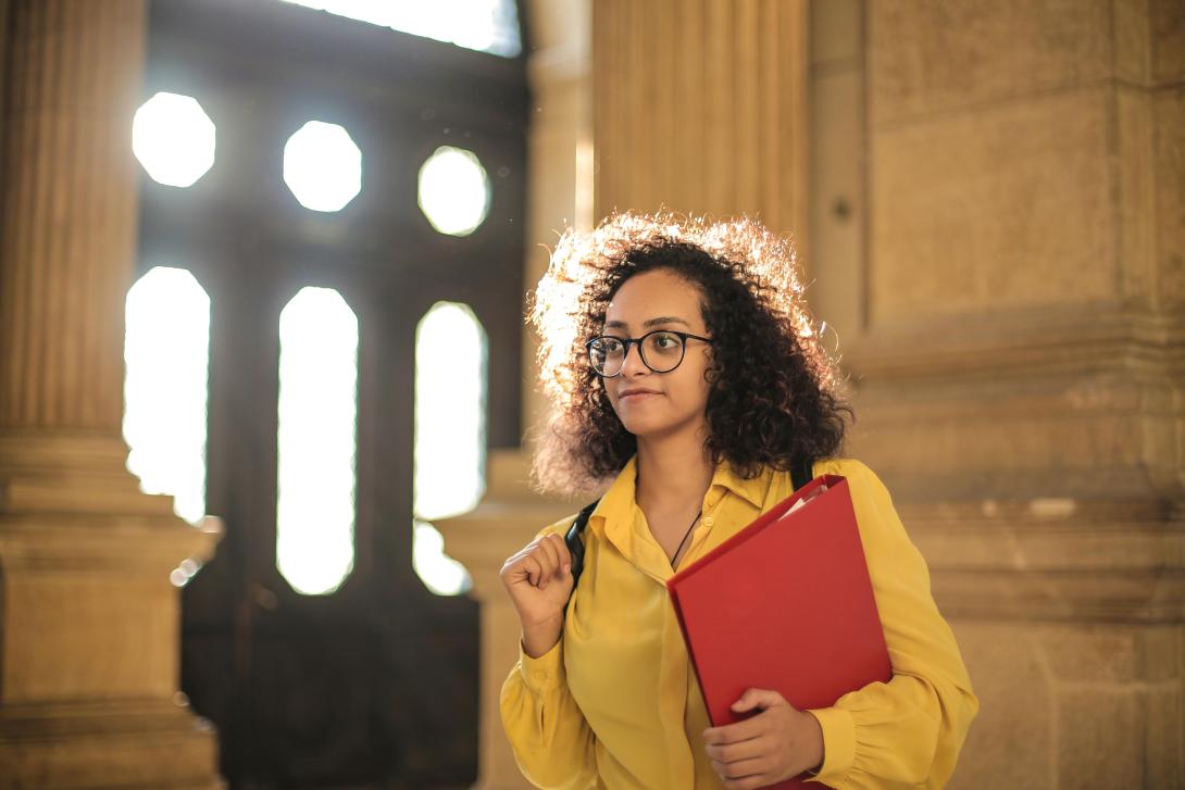 Individual carrying a binder heading to class